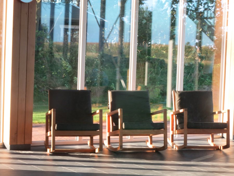 Zona relax di un hotel di lusso con poltrone accanto a grandi finestre