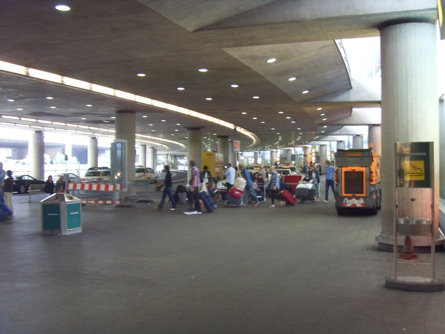 Navetta aeroportuale e viaggiatori con bagagli al terminal