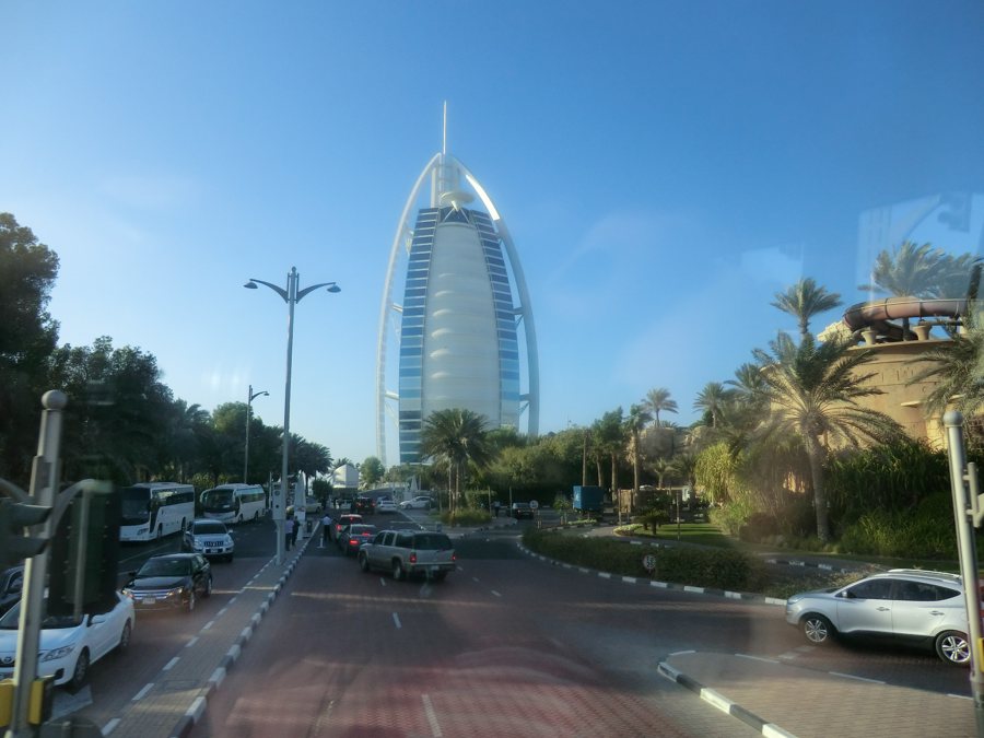 Il Burj Al Arab oltre una strada trafficata e palme a Dubai