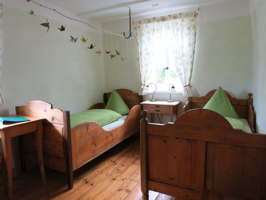 Camera d’hotel con due letti in legno e scrivania
